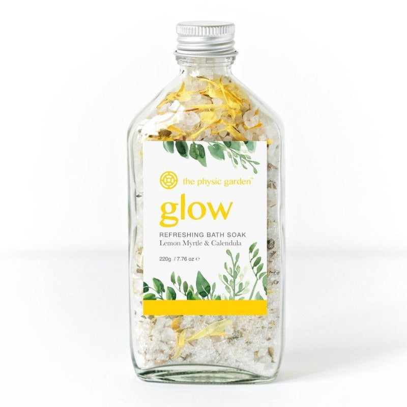 The Physic Garden&#39;s Glow Refreshing Bath Soak in a 220g jar with lemon myrtle essential oil and calendula petals on a white background.
